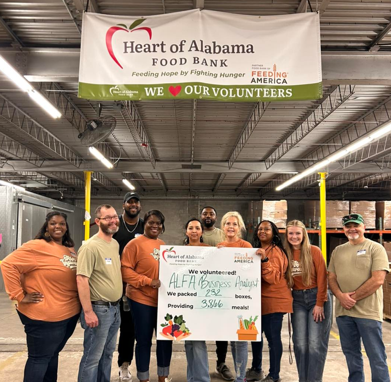 Alfa employees working with Heart of Alabama food bank and holding big check